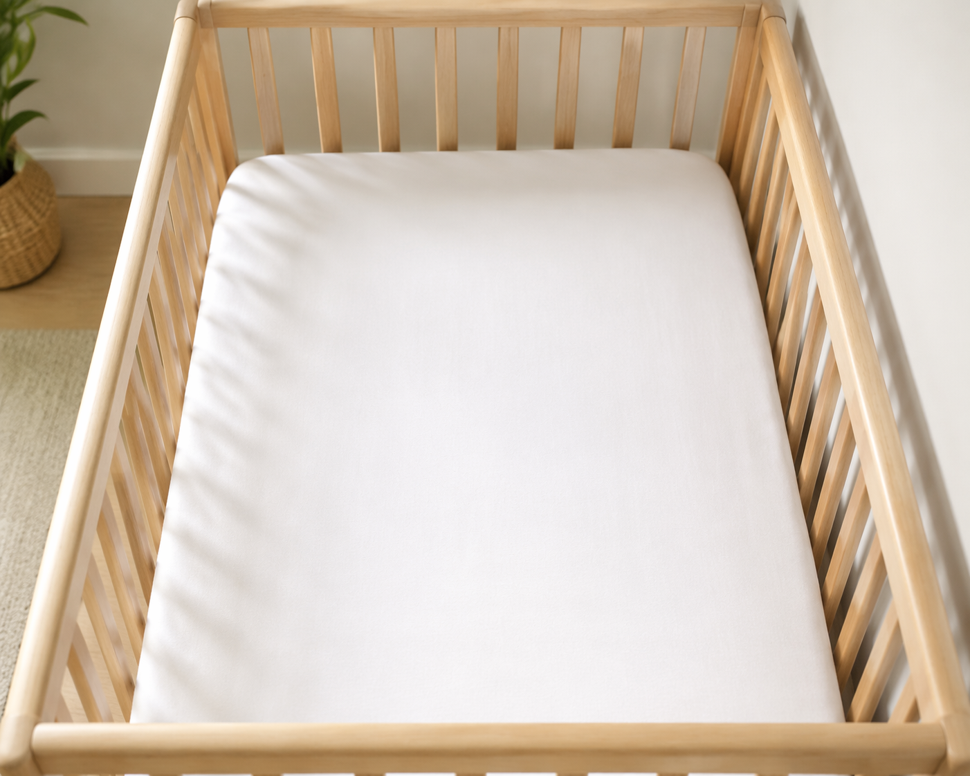Safe infant crib with only a fitted sheet and no loose bedding, bumpers, pillows, toys, or blankets