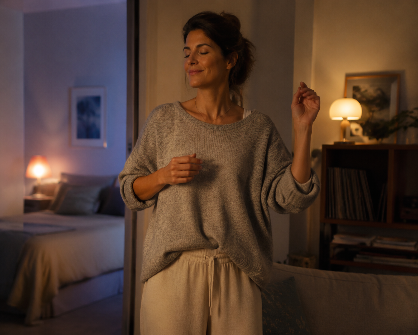 Woman gently swaying in a cozy evening living room with a bed visible in the background
