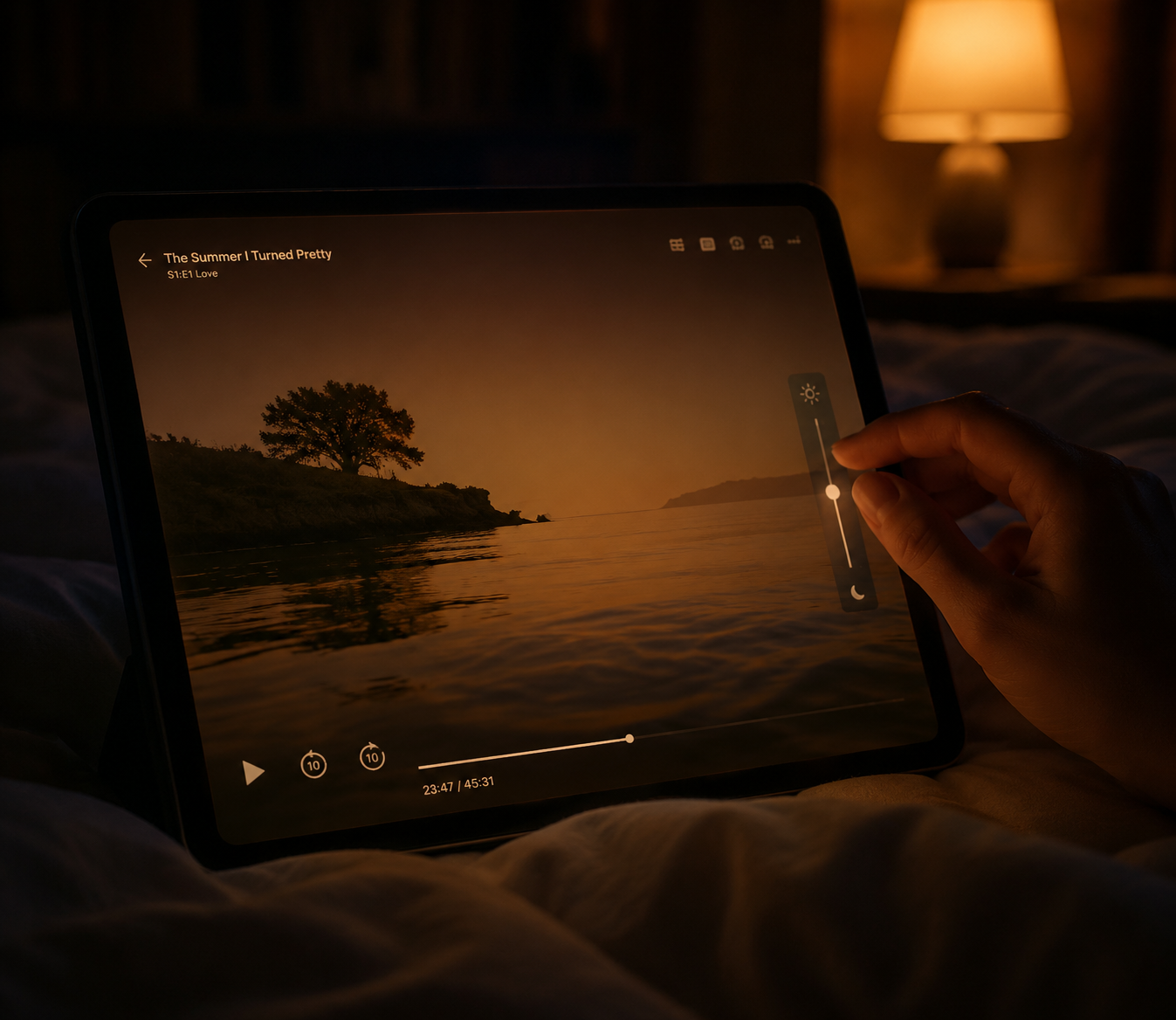 Hand lowering tablet brightness with night mode active in a dark bedroom
