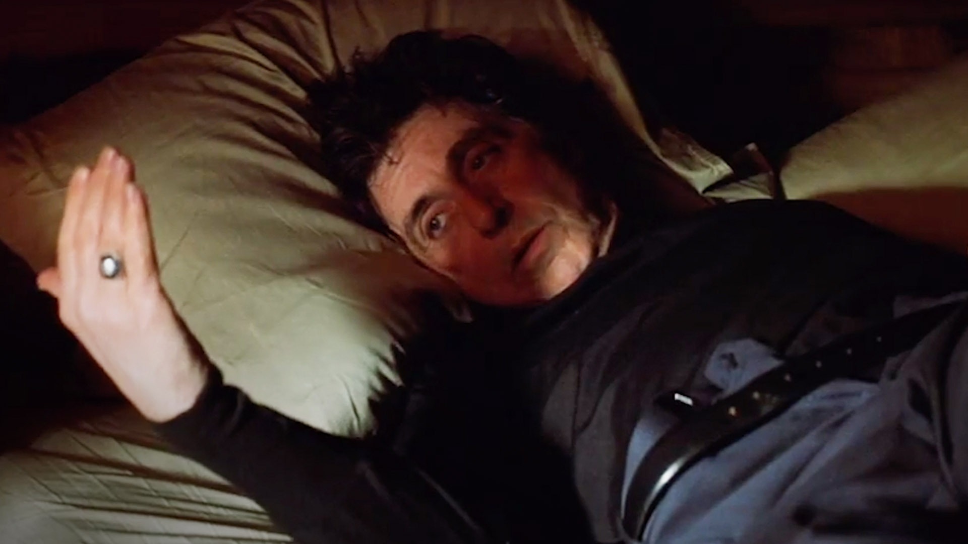 Al Pacino as Detective Will Dormer with heavy, exhausted eyes in a dimly lit Alaskan hotel room