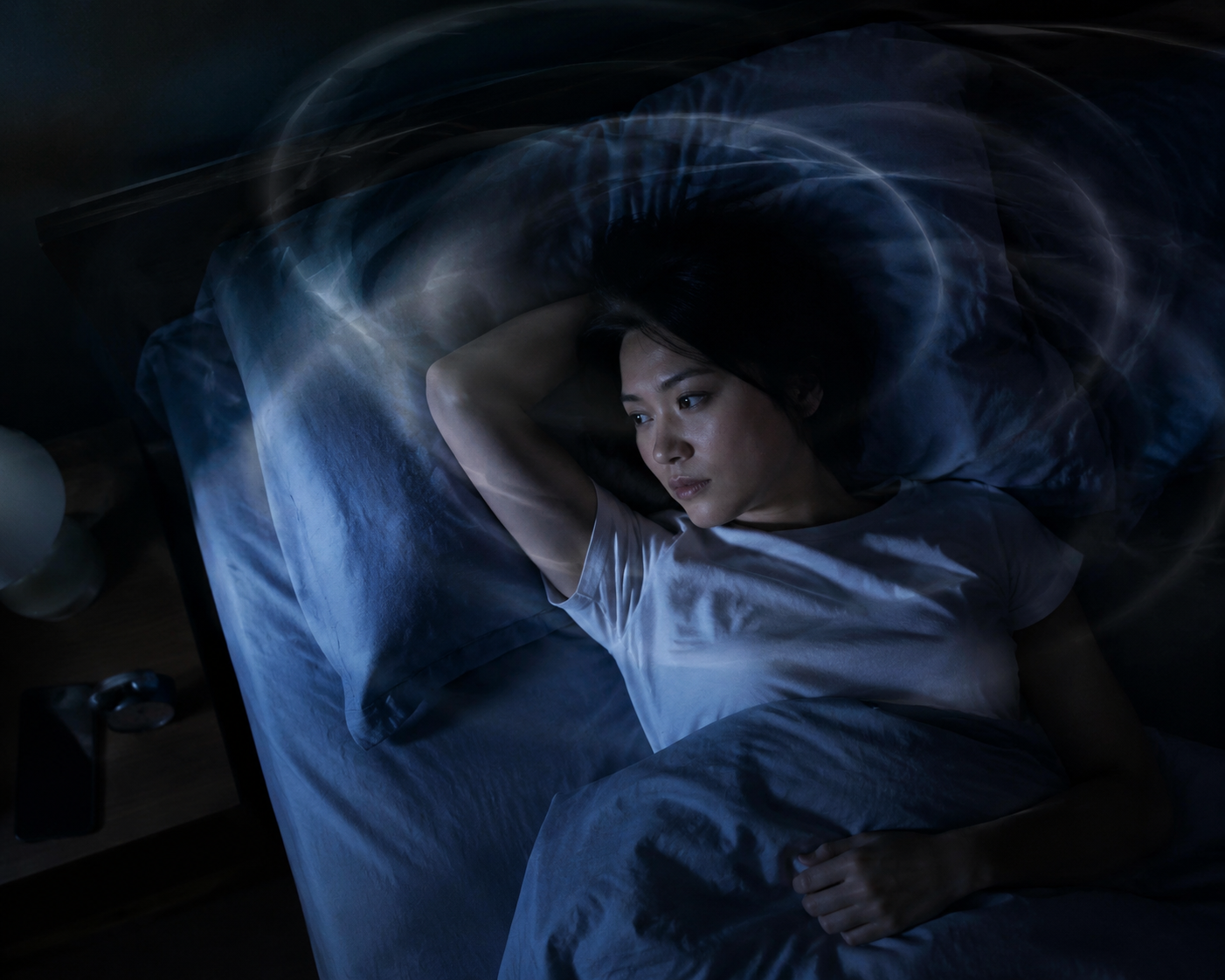 A person lying awake in bed at night with circular anxious thought trails above them