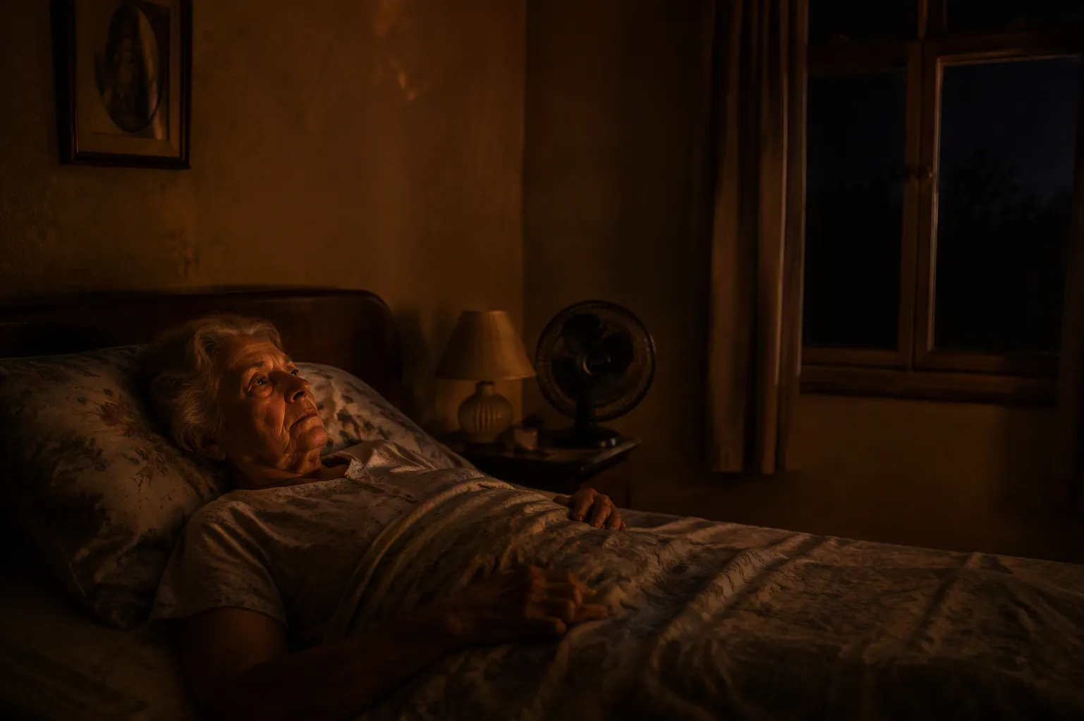 Older adult awake in a warm bedroom during a nighttime power outage